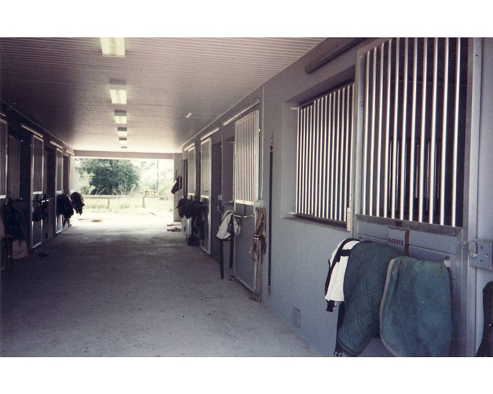 Aluminum horse stalls with sliding T&G doors and front grills.