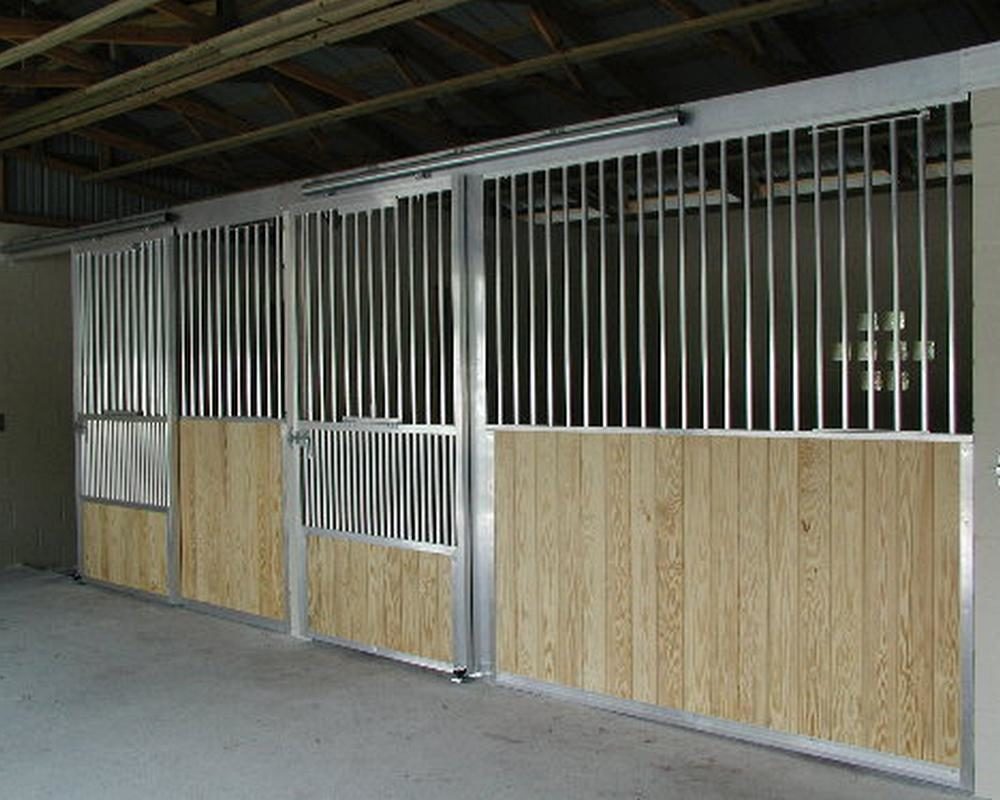 Aluminum horse stall front grills with tongue and groove plank lumber walls.