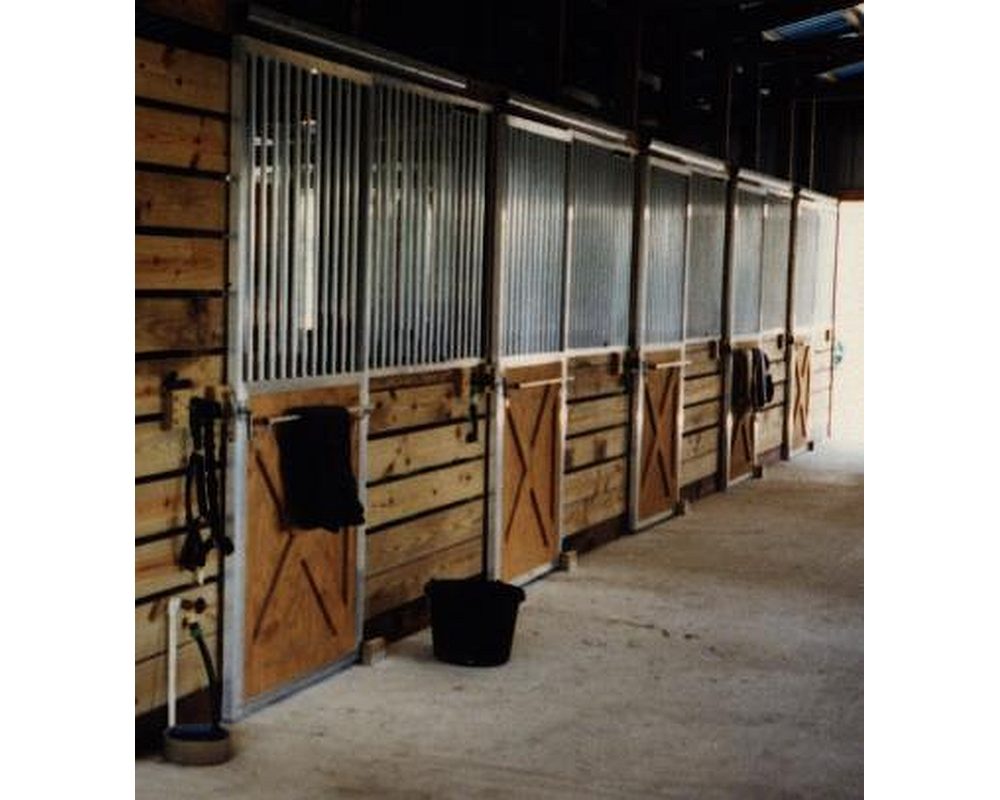 Row of crossbuck bar top sliding horse stall doors.
