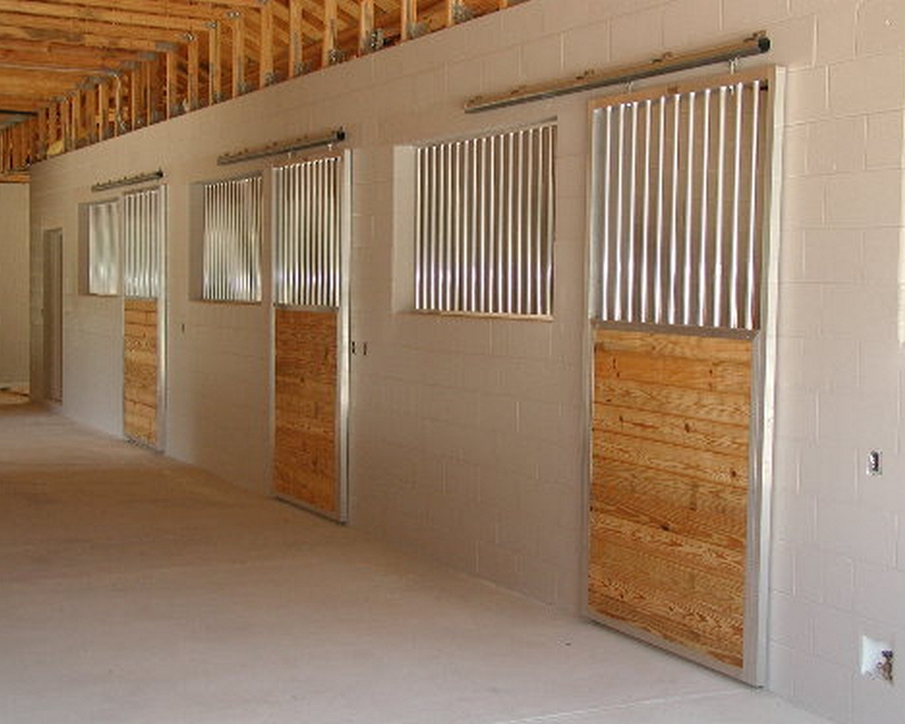 Horse stall front with sliding doors and front grills.