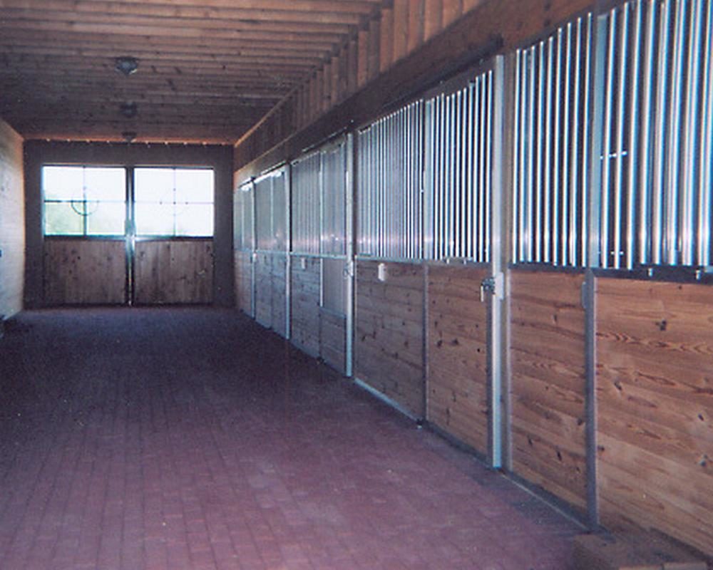 Horse barn aisle with aluminum stall products.