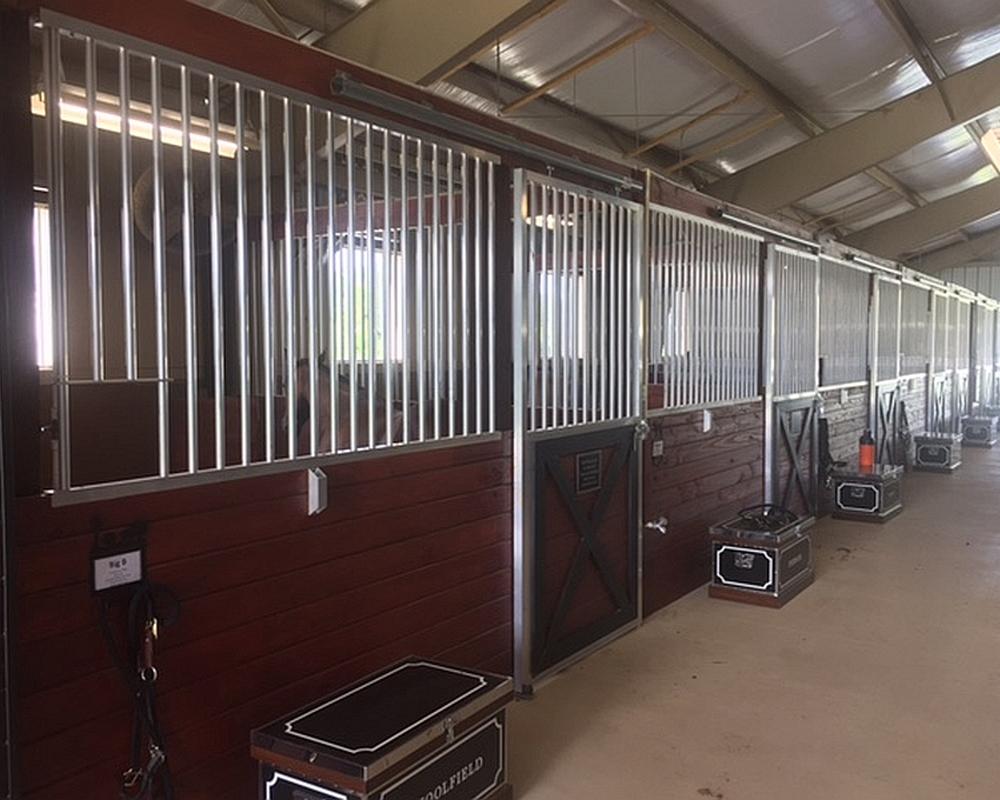 Sliding horse stall doors and aluminum stall front grills.