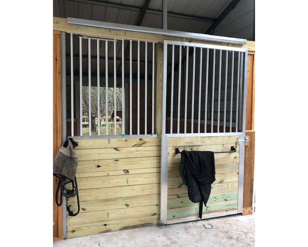 Horse stall front with sliding stall door and stall front grill.