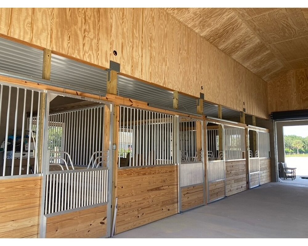 Sliding horse stall doors with gossip top and coolbreeze scuff panel bottoms.
