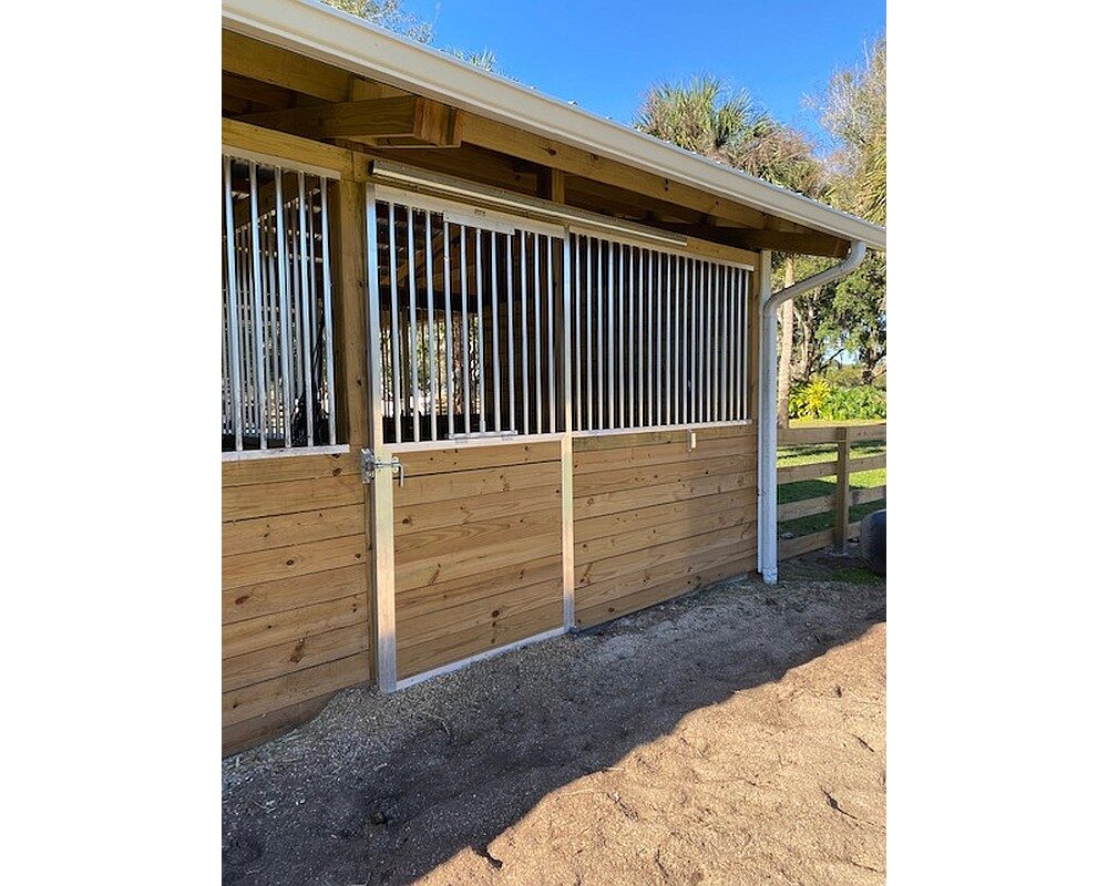 Hunt stables featuring sliding doors on the back of the stalls and added grills for cross breezes in the hot and humid Florida summers.