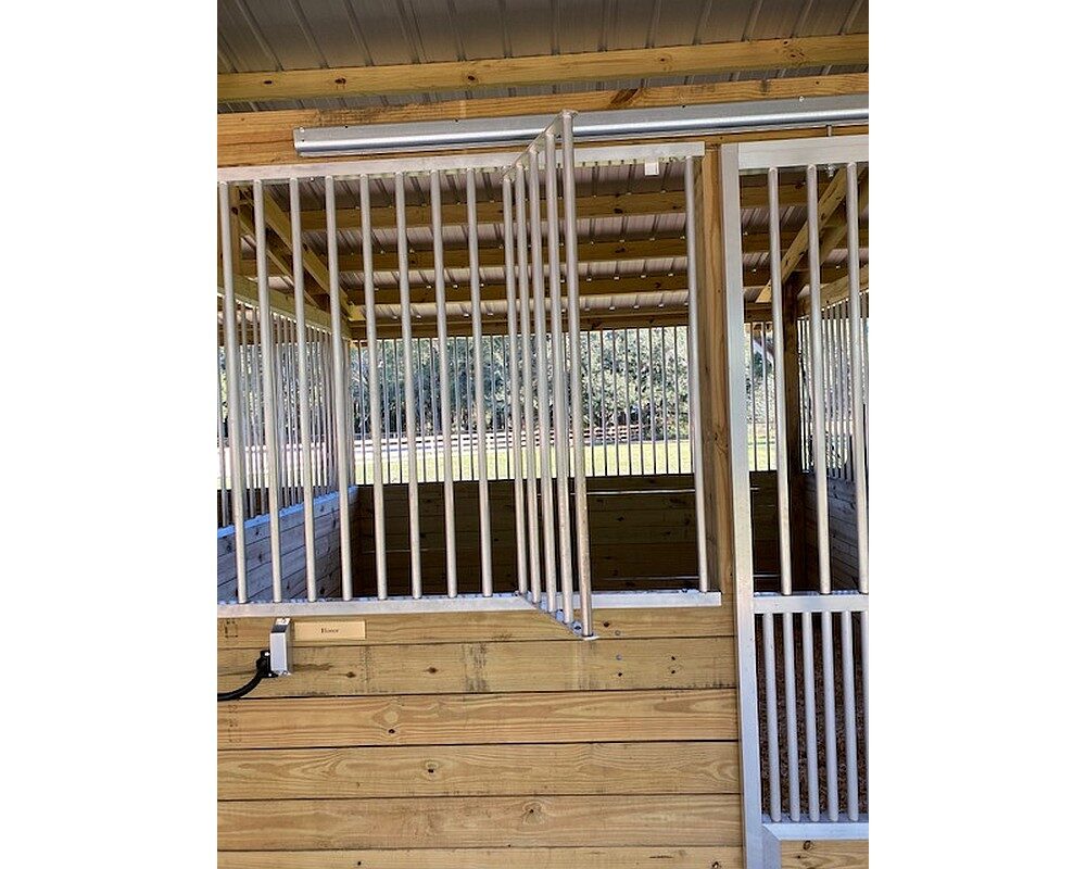 Feeder access door in stall front grill opens for easy feeding access.