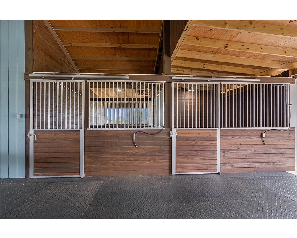 Sliding stall door superstructure and aluminum stall front grills.